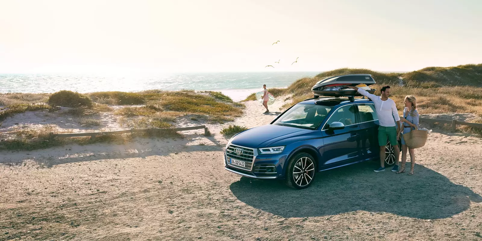 Una pareja con un coche de alquiler, VW FS | Rent-a-Car, en la playa